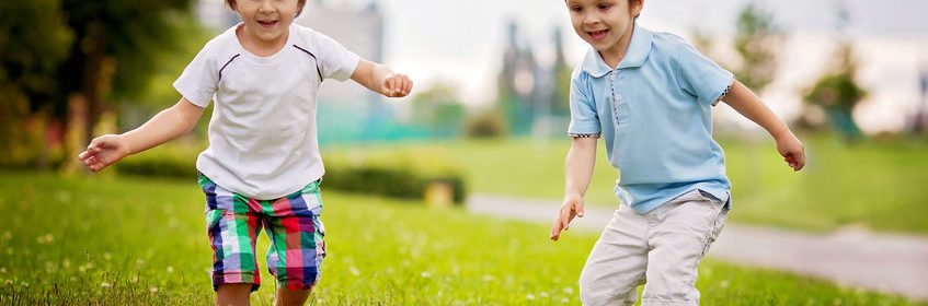 Un niño jugando con una pelota de fútbol en el pasto Descripción generada automáticamente con confianza media